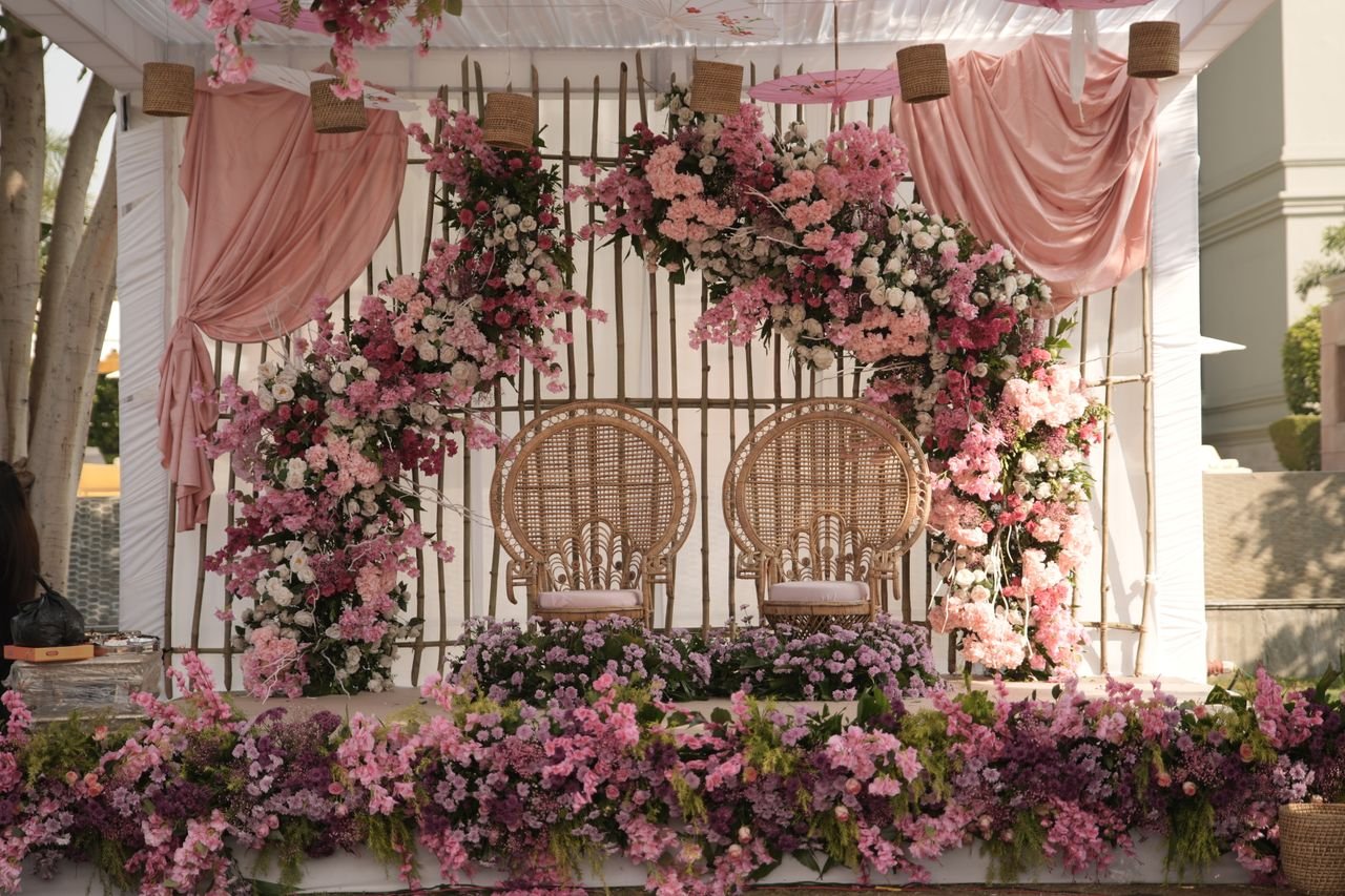 Beautiful Indian wedding haldi ceremony setup with floral decorations and wicker chairs.